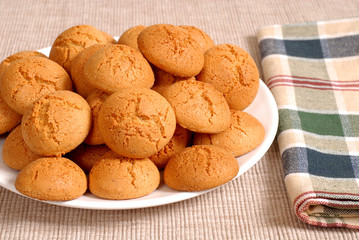 plate of crisp italian amaretti cookies with a checkered napkin
