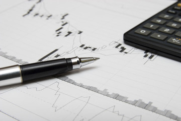 candlesticks chart, pen and calculator