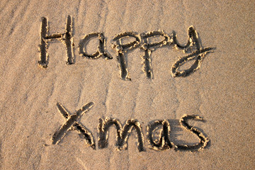 happy xmas, written on the beach.