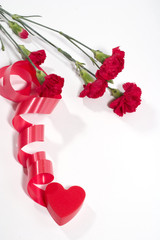 Fototapeta na wymiar carnation and red plastic heart