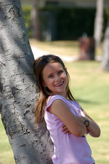girl leaning on tree