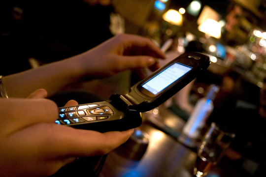 mains envoyant un message sms