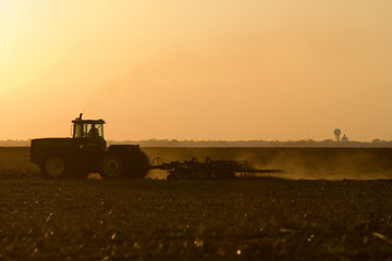 Naklejka premium silhouette of farmer tilling his land after the ha