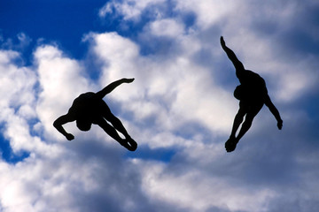 Fototapeta na wymiar synchronized divers in the sky