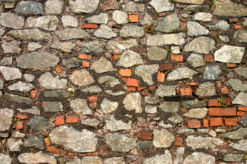 an old stone wall including some red bricks.