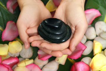 hands holding basalt stones