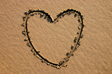 a heart shape drawn in the sand.
