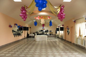 decorated wedding reception room with dance floor, party room