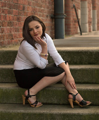 cute young business woman sitting on steps