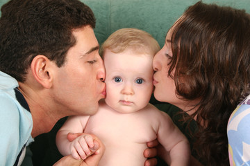 parents kissing baby