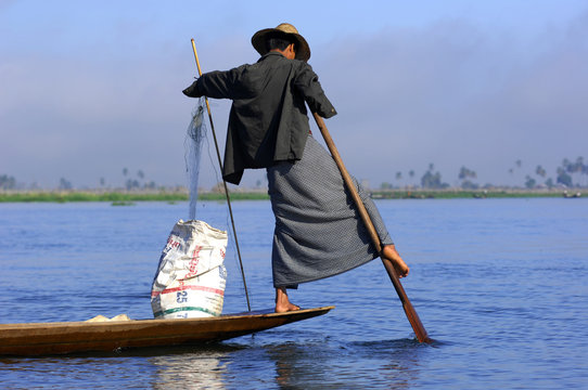 myanmar, inle lake: fishermen on the lake paddling with the help