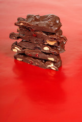 chocolate cashew and dried cherry bark on a red background