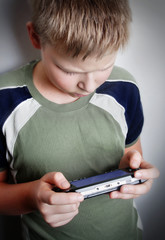 boys hand playing portable video game
