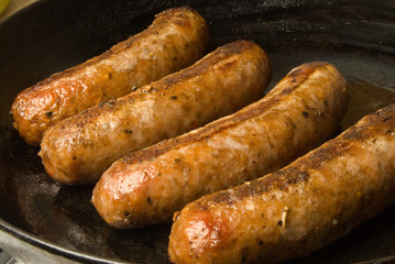 sausages in a black frying pan