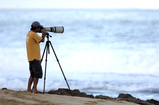 Fototapeta man taking photo on beach
