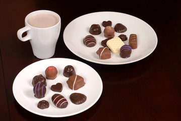 two plates of chocolates with a cup of hot chocolate