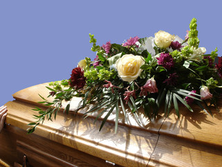 casket with flowers, blue sky
