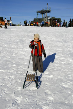 boy with sled in winter time