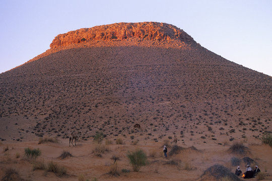 bivouac de chameliers pr&egrave;s d'une colline rocheuse