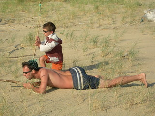 père et fils jouant aux aventuriers sur la plage