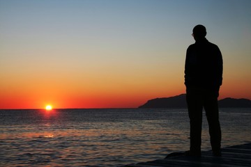 Fototapeta premium man looking on sunset