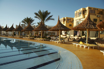 Obraz na płótnie Canvas swimming-pool and parasols group on resort