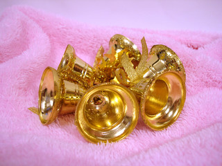 golden christmas handbells on pink background