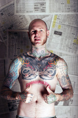 tattoo man in front of newspapers
