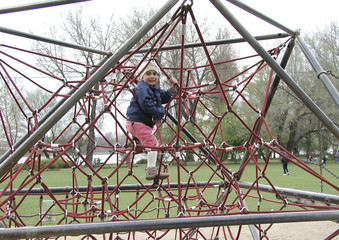 kind beim klettern auf dem spielplatz