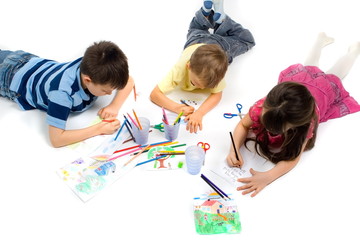 three children drawing on floor