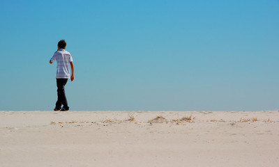 teen walking away on beach