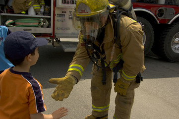 Naklejka premium firefighter in uniform with a child