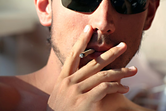 jeune fumeur sur la plage