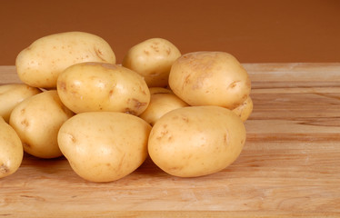several white potatoes piled on a cutting board