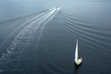 One sail boat and one yacht heading in different  direction. Beautiful ripples in the water.