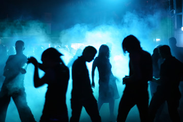 silhouetten von jungen discotänzer im nebel