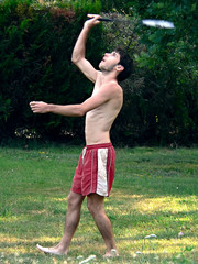 jeune homme en short jouant au badminton en jardin