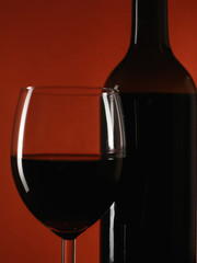 bottle and glass over deep red