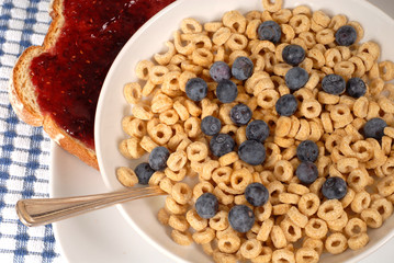 overhead view of oat cereal with blueberries and spoon, toast wi