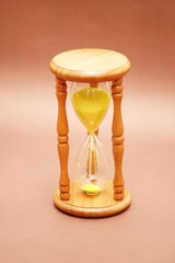 wooden hourglass against brown background