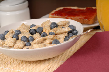 wheat cereal with blueberries, toast and orange juice