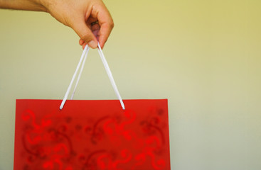 red gift bag in man's hand