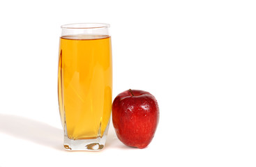 glass of apple juice with an apple next to glass