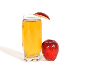 glass of apple juice with an apple wedge and apple next to glass