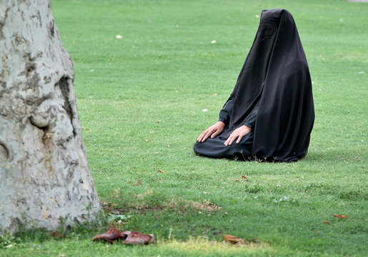 woman sitting on grass in full hijab (wearing para
