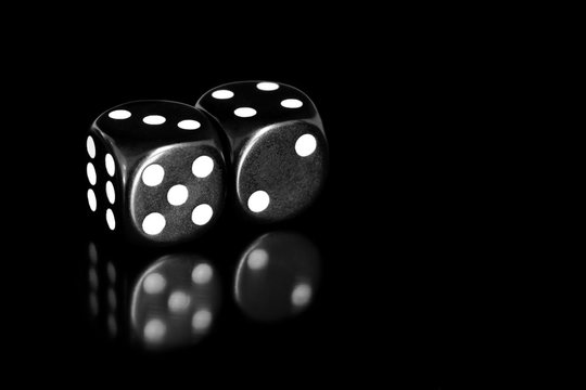 black and white dice reflected on black