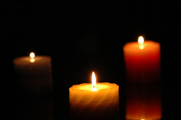 three candles in the darkness - focus on the middle one