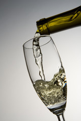 white wine pouring into wineglass
