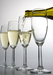 white wine pouring from bottle into wineglass