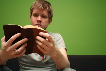 young man reading small bible